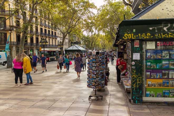 Ảnh La Rambla ở Barcelona, Tây Ban Nha là con đường dài 1,2 km nối từ quảng trường Catalunya ở trung tâm đến đài tưởng niệm Christopher Columbus ở bến cảng Port Vell. Giữa trung tâm đường La Rambla là phố đi bộ nhộn nhịp và sôi động với nhiều hàng quán, quầy bán đồ lưu niệm dọc hai bên đường, luôn tấp nập người qua lại cả ngày lẫn đêm. Đi trên con đường này, du khách có thể ghé chợ cổ La Boqueria nổi tiếng với hoa quả và hải sản tươi. Ảnh: Martijn Vonk/Unsplash.